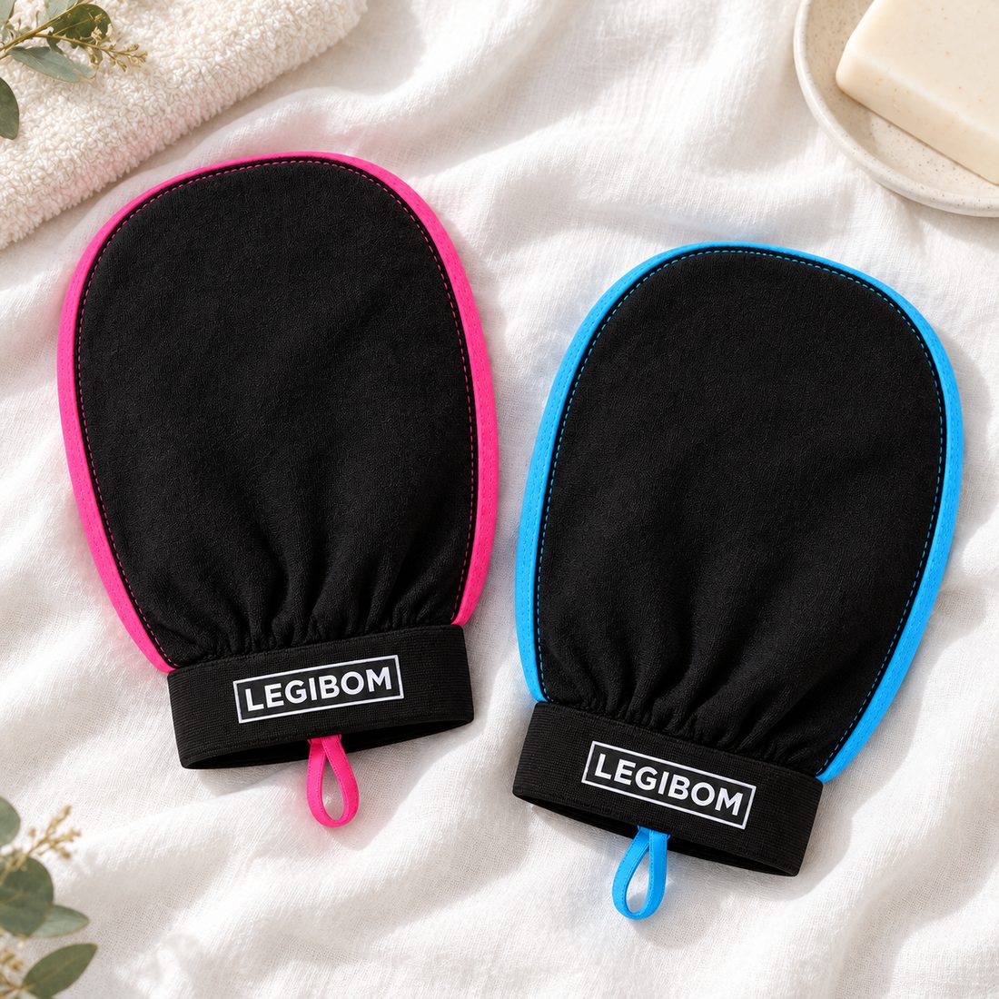 Legibom exfoliating mitts: one with pink trim, one with blue trim, on white linen